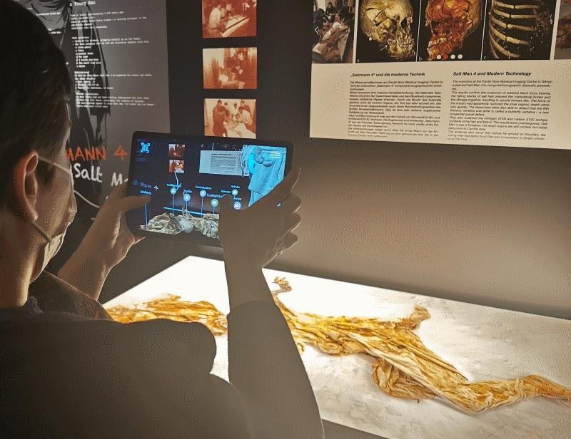 A museum visitor using a tablet as an interactive educational device